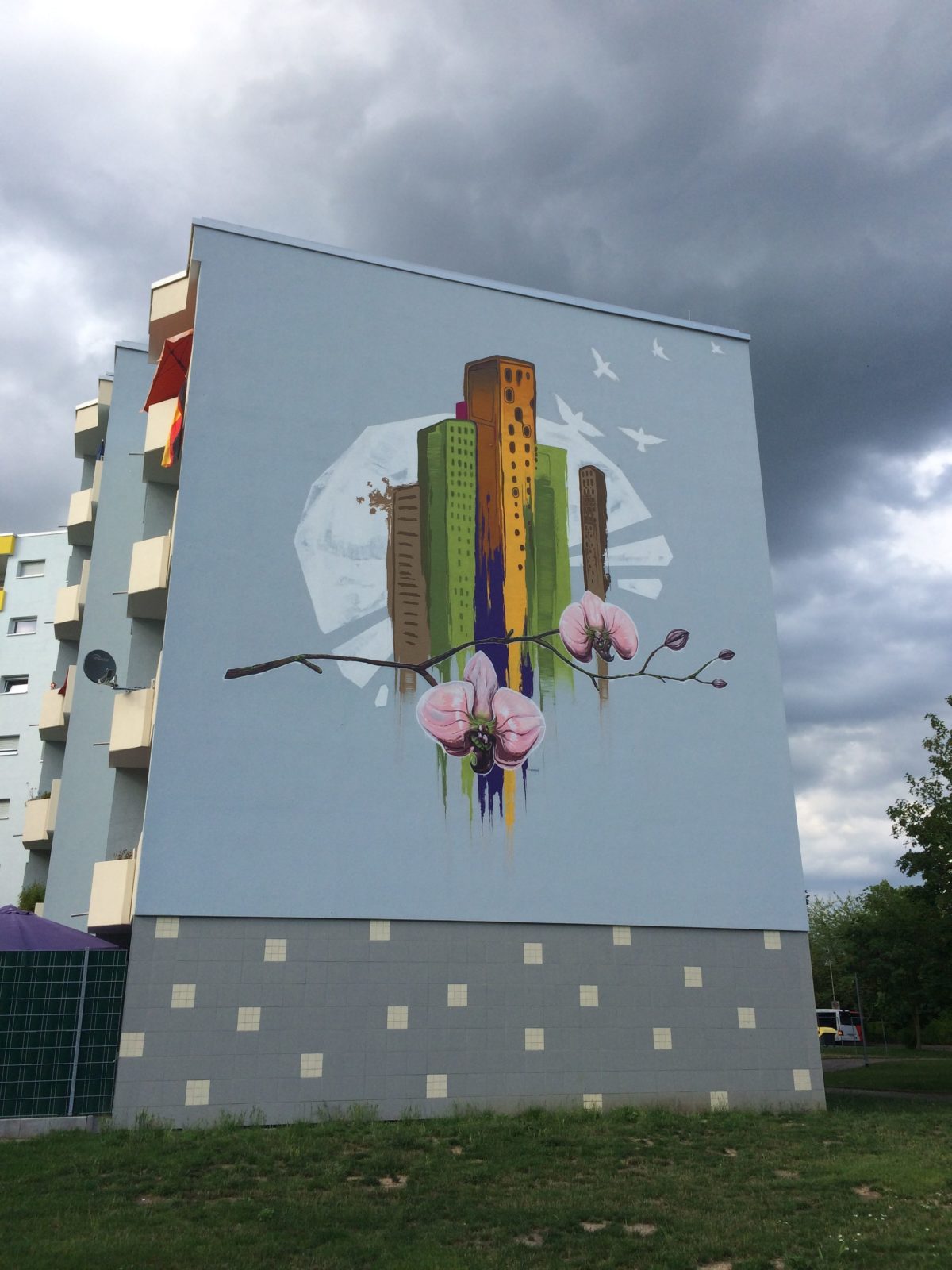 graffitiauftrag-graffitikuenstler-artmos4-Baugenossenschaft_Odenwaldring_2012_skyline_landschaft_aussen_gebäude_bunt_kunst