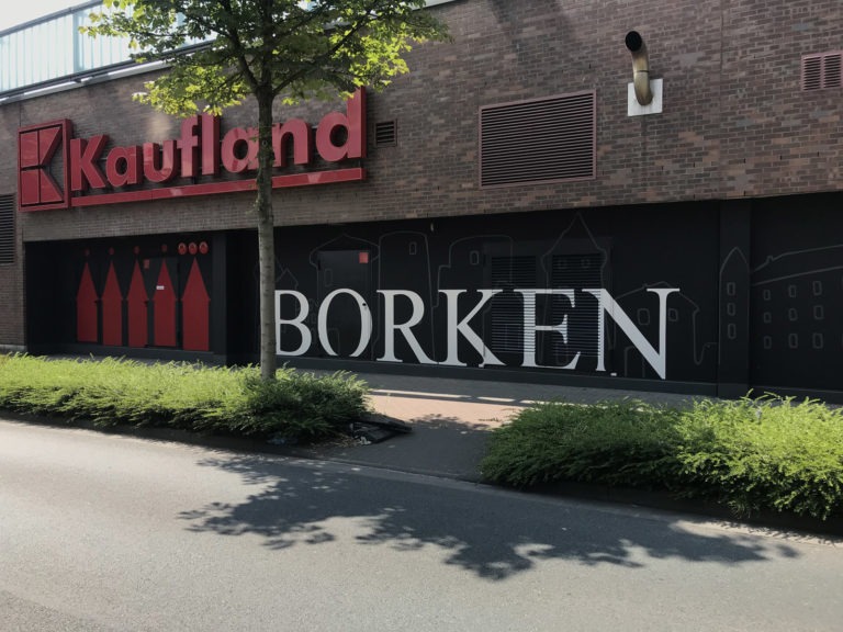 graffitiauftrag-graffitikuenstler-artmos4-borken-kaufland-typo-skyline-logo-schwarz-rot-aussen-folie