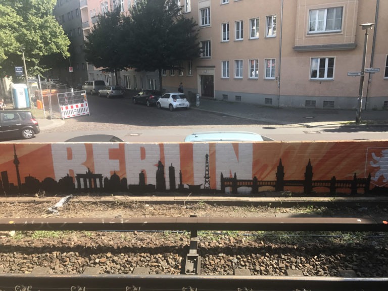 graffitiauftrag-graffitikuenstler-artmos4-deutsche-bahn-berlin-skyline-landschaft-schrift-schwarz-weiss-orange-aussen-illustrativ-verkehrsbetrieb