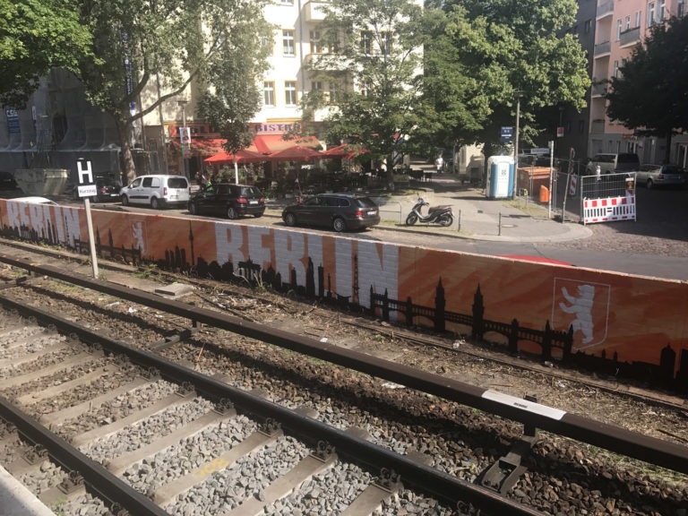 graffitiauftrag-graffitikuenstler-artmos4-deutsche-bahn-berlin-skyline-landschaft-schrift-wappen-schwarz-weiss-orange-aussen-illustrativ-verkehrsbetrieb
