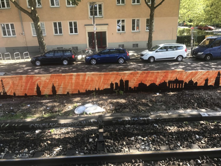 graffitiauftrag-graffitikuenstler-artmos4-deutsche-bahn-berlin-skyline-landschaft-schwarz-orange-aussen-illustrativ-verkehrsbetrieb
