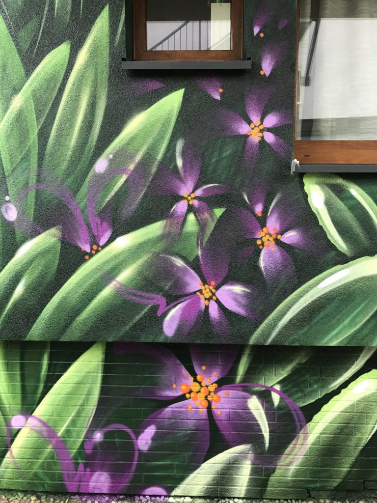 graffitiauftrag-graffitikuenstler-artmos4-fdk-liegenschaft-pflanzen-lila-landschaft-gruen-kunst-aussen
