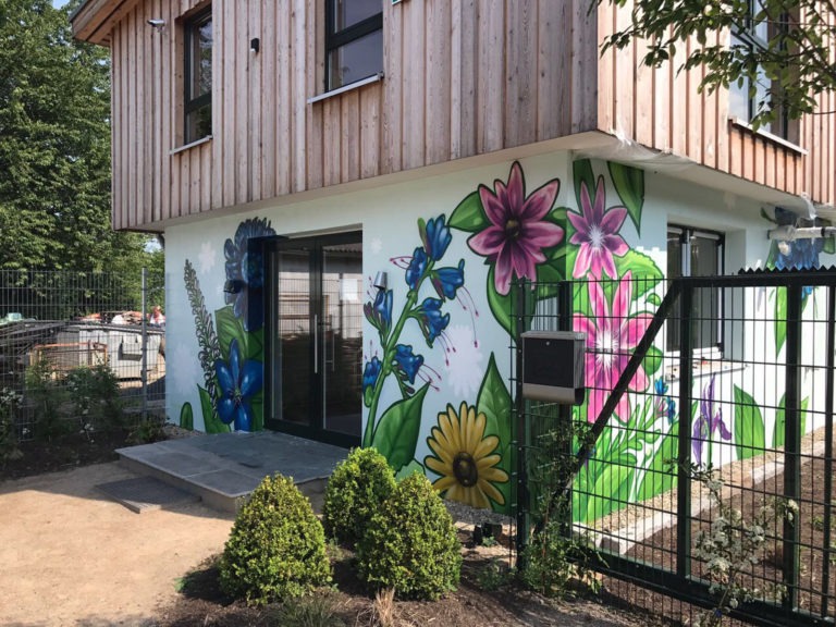 graffitiauftrag-graffitikuenstler-artmos4-gruenerleben-pflanzen-gruen-bunt-blau-illustrativ-aussen