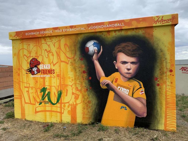 graffitiauftrag_graffitikuenstler_artmos4_HSG_Eckbachtal_Gekko_Friends_ 2022_Mensch_Tier_Gekko_Trafostation_Handballer_Justus_Schrift_Graffiti_Tags