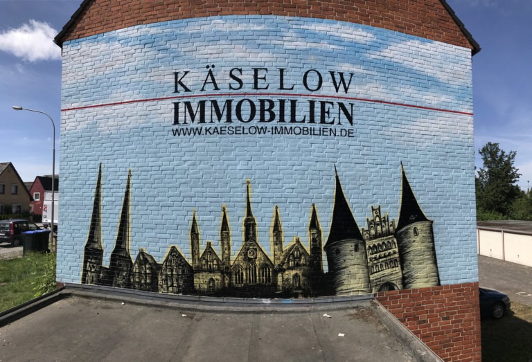 graffitiauftrag-graffitikuenstler-artmos4-kaeselow-himmel-landschaft-blau-gelb-schrift-schwarz-immobilien-aussen-illustrativ