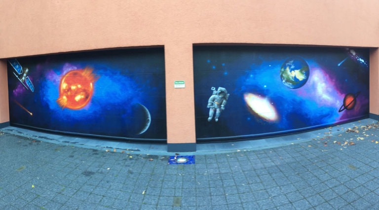graffitiauftrag-graffitikuenstler-artmos4-kuhn-garage-weltall-planet-astronaut-mensch-sonne-objekt-blau-schwarz-illustrativ-privat