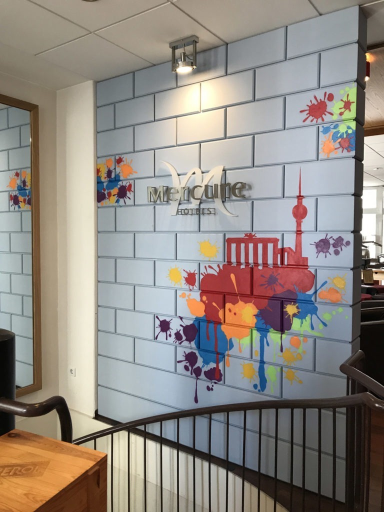 graffitiauftrag-graffitikuenstler-artmos4-mercure-hotel-berlin-skyline-sehenswuerdigkeiten-innen-bunt-folie-hotel
