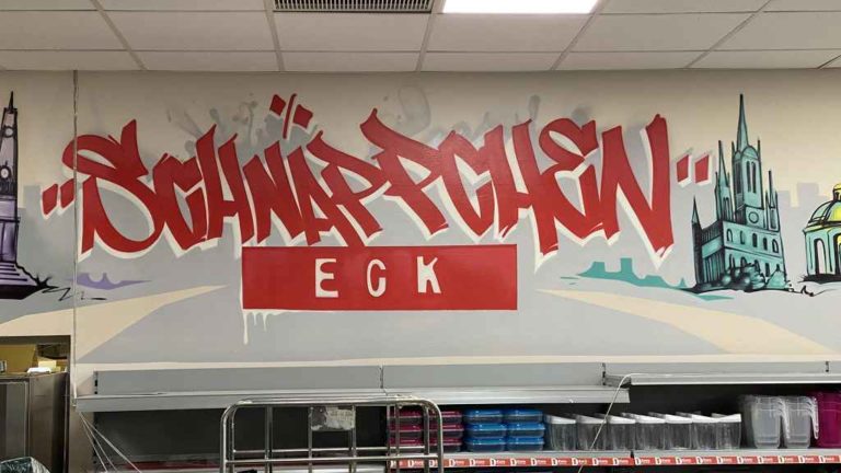 graffitiauftrag_graffitikuenstler_artmos4_Nahkauf_Kleinfeldchn_2022_Graffit_schriftzug_Sehenswürdikeiten_Skyline_Gebäude_style_02