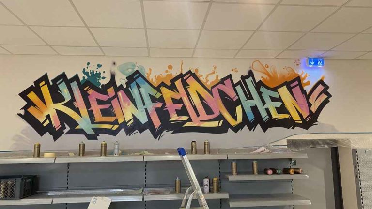 graffitiauftrag_graffitikuenstler_artmos4_Nahkauf_Kleinfeldchn_2022_Graffit_schriftzug_Sehenswürdikeiten_Skyline_Gebäude_style_03