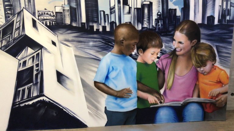 graffitiauftrag-graffitikuenstler-artmos4-nassauische-innen-skyline-frankfurt-menschen-lesen-buch-foto-polaroid-blau-weiss-fotorealistisch-illustrativ