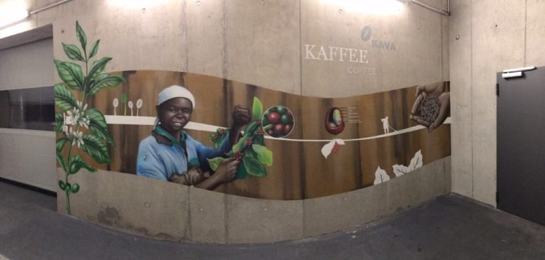 graffitiauftrag-graffitikuenstler-artmos4-new-coffee-aldi-weltkarte-schrift-mensch-pflanzen-kaffee-innen-beige-braun-illustrativ