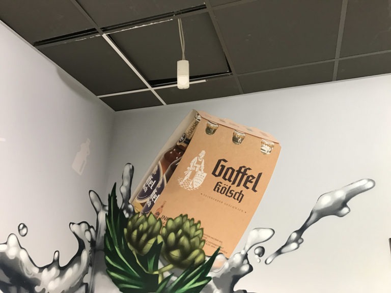 graffitiauftrag-graffitikuenstler-artmos4-rewe-istas-flasche-pflanzen-wasser-innen-grau-fotorealistisch-getraenke-handel