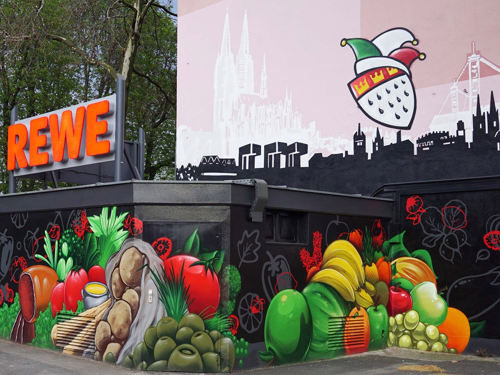 graffitiauftrag-graffitikuenstler-artmos4-rewe-skyline-obst-gesicht-schrift-wappen-aussen-schwarz-bunt-fotorealistisch-illustrativ-handel