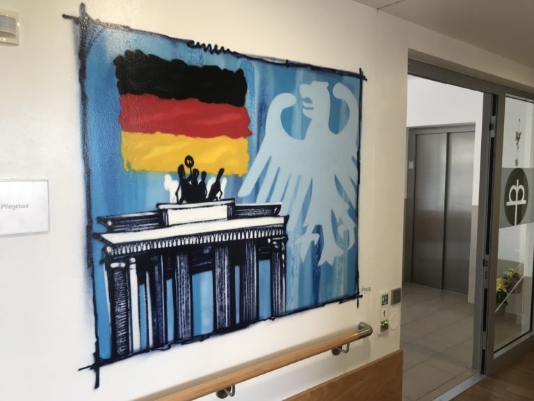 graffitiauftrag-graffitikuenstler-artmos4-rummelsberger-diakonie-weltkarte-laender-deutschland-flagge-sehenswuerdigkeiten-innen-illustrativ-bunt