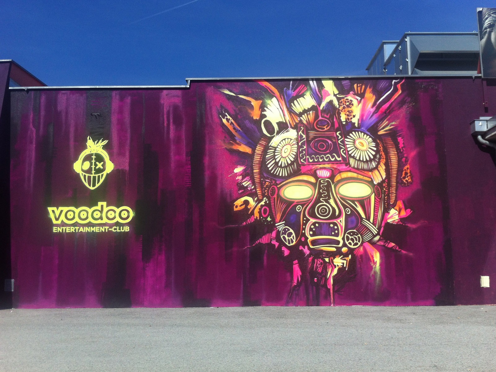 graffitiauftrag-graffitikuenstler-artmos4-voodoo-disco-fassadengestaltung-maske-neon